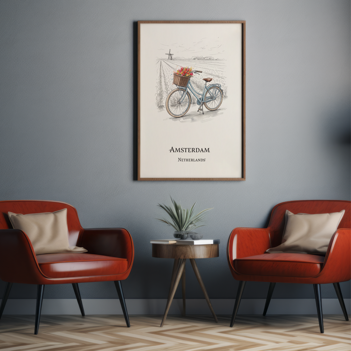 A framed vintage-style Amsterdam bicycle poster hangs on a grey wall above two red armchairs and a small round side table with a plant.
