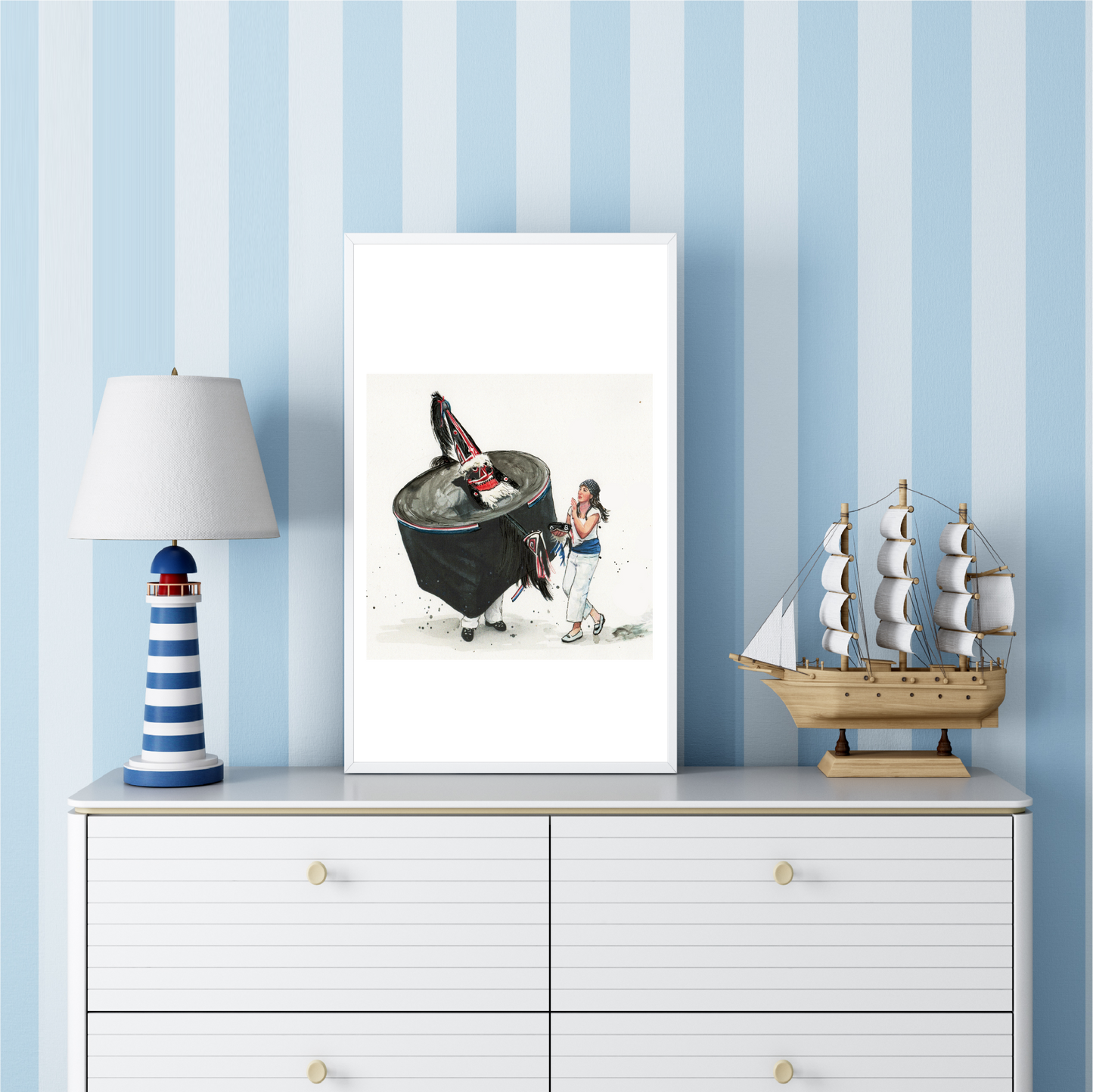 Padstow Blue Obby Oss watercolour travel poster in a frame on a white dresser with striped blue wallpaper