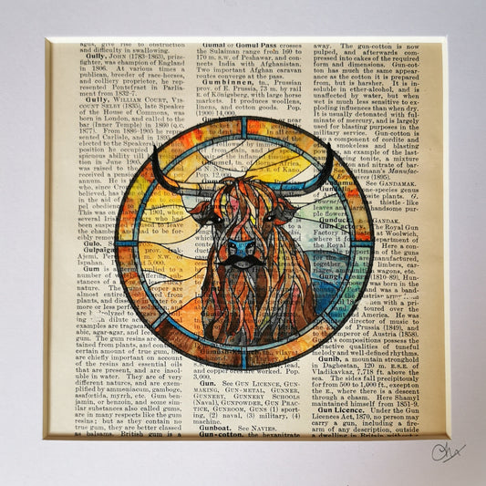 Framed artwork featuring a watercolour and ink illustration of a Highland Cow on a vintage encyclopaedia page.
