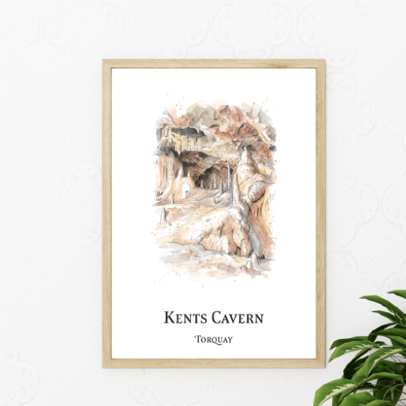 A framed art print of Kents Cavern in Torquay, featuring a watercolor illustration of the cave entrance with the text 'KENTS CAVERN' and 'TORQUAY' below, styled on a white wall next to a green plant.