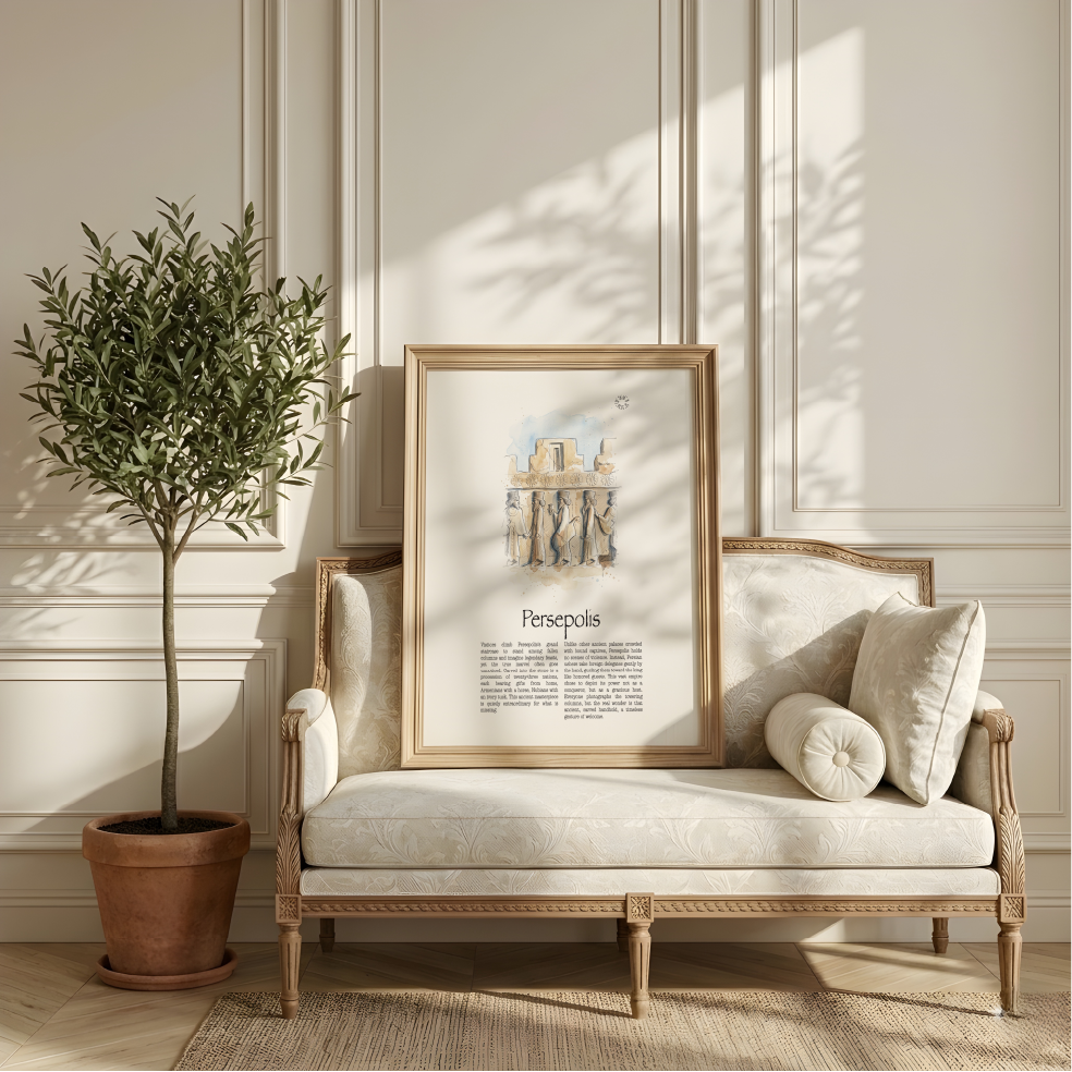 A framed art print of the grand staircase at Persepolis, in Iran, featuring a classic watercolour landscape in a light wood frame, styled on a cream-coloured sofa next to a potted olive tree in a bright, elegant room.