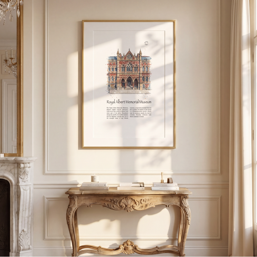 A framed watercolour art print depicting The Royal Albert Memorial Museum in Exeter, hung on a cream-coloured wall above a decorative console table in a sunlit room.