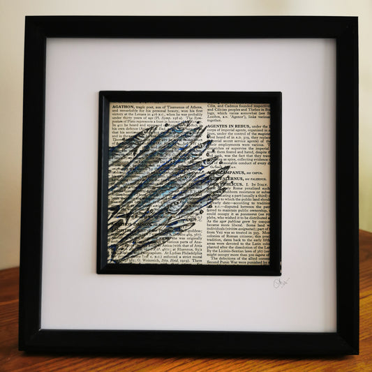 Framed artwork featuring a watercolour and ink illustration of a shoal of sardines on a book page, set in a black frame.