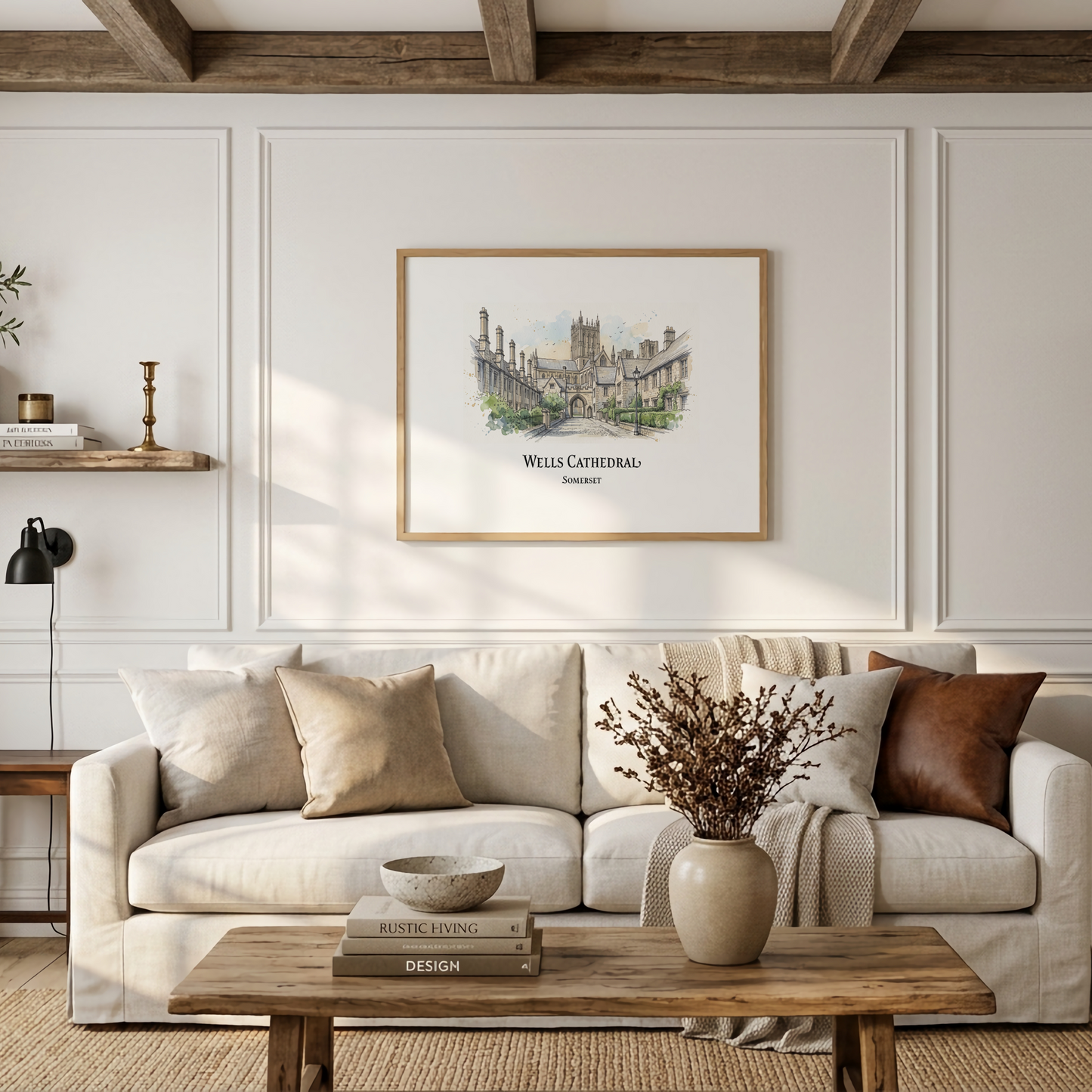 A framed art print of Wells Cathedral, England, hangs on a white paneled wall above a beige sofa in a styled living room with a wooden coffee table and decorative pillows.