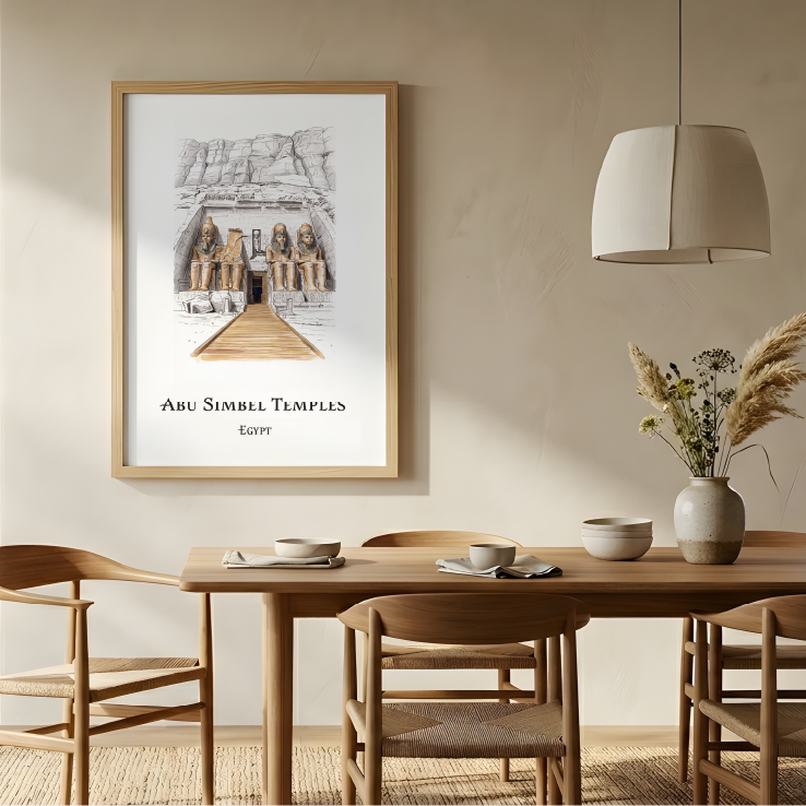 A framed art print of Abu Simbel Temples in Egypt, displayed on a beige wall in a modern, minimalist dining room setting with a wooden table, chairs, and a hanging lamp.