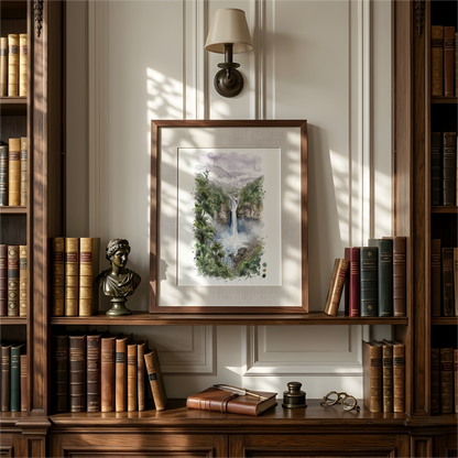 A framed watercolour painting of a colourful Amazon Rainforest in Peru, hangs on a paneled wall between dark wood bookshelves filled with books. A wall lamp is above, and a small bust and books sit on the shelf below.