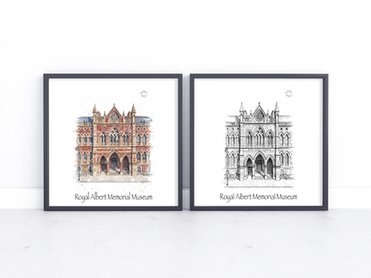 Two framed art prints of the Royal Albert Memorial Museum in Exeter, one in a watercolour style with warm red-brown tones and one in black and white line art, displayed side-by-side on a white surface against a white wall.