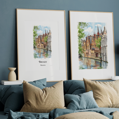 Two framed watercolour prints of Bruges, Belgium, displayed side-by-side on a dark blue wall above a bed with beige and blue pillows.