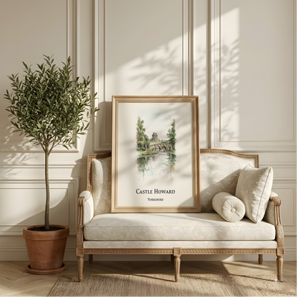 A framed art print featuring a watercolour landscape of Castle Howard, Yorkshire, styled on a cream-coloured wooden chaise lounge next to a potted olive tree in a bright, elegant room.