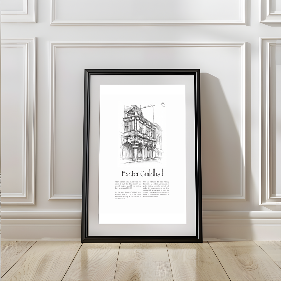 A framed black and white architectural art print of Exeter Guildhall, leaning against a white paneled wall on a light wood floor.