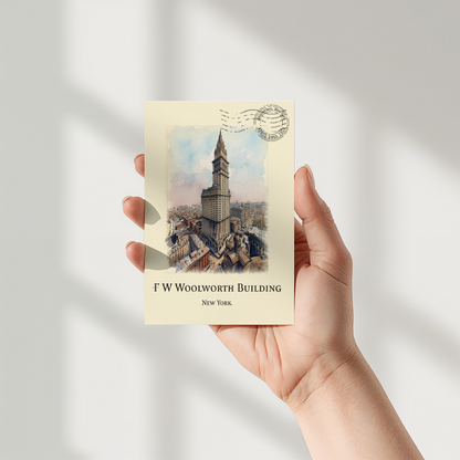 A hand holding a cream-coloured postcard featuring a vintage illustration of the F.W. Woolworth building in New York
