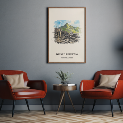 A framed art print titled 'Giant's Causeway' hangs on a dark gray wall in a modern living room setting with two red armchairs, a small side table, and a floor lamp.
