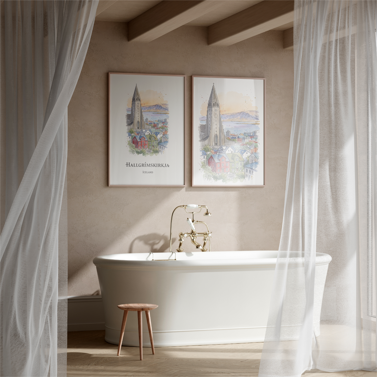 A styled bathroom scene with a white freestanding bathtub, gold faucet, sheer white curtains, and two framed vertical art prints hanging on the beige wall above the tub. The prints depict a church spire and a coastal city scene with the text 'HALLGRËUSKERJUN' and 'Iceland'.