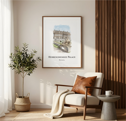 A framed art print featuring a watercolour illustration of Herrenchiemse Palace in Rotterdam, hung on a beige wall in a modern, sunlit living room setting with a wooden armchair, a potted plant, and a side table.