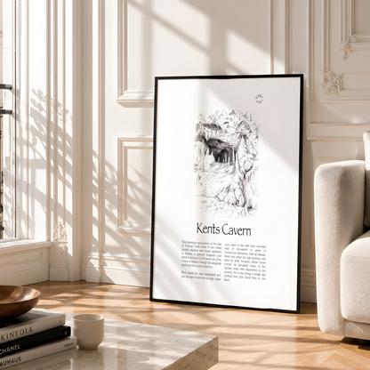 A framed black-and-white art print titled "Kents Cavern" leaning against a cream wall in a sunlit Parisian-style room with wood floors, a sofa, and a marble coffee table.