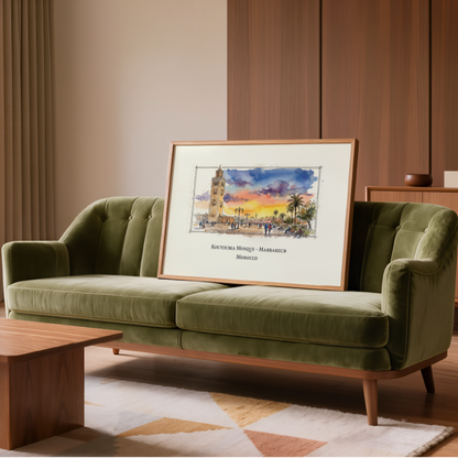 A framed art print depicting a colourful sunset over the historic Marrakech square in Morocco styled on a green velvet sofa in a modern, warm-toned living room.