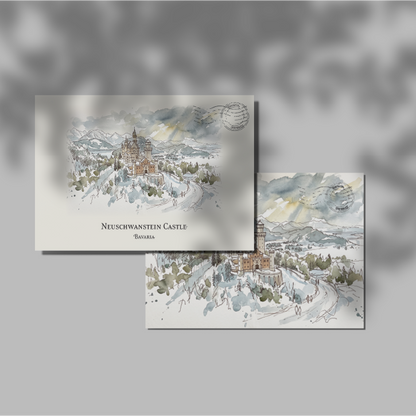 Two rectangular art postcards featuring a watercolour winter landscape with snow-covered mountains, Neuschwanstein Castle, trees, and soft gray-blue sky tones, displayed on a light gray background with leaf shadows.