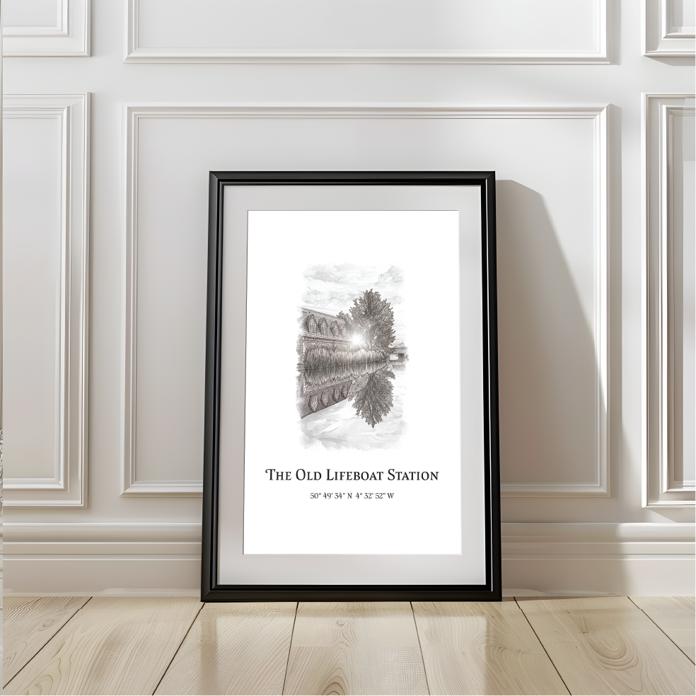 A framed black-and-white art print titled "The Old Lifeboat Station" leaning against a white paneled wall on a light wood floor.