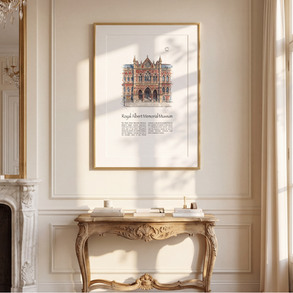 A framed watercolour art print depicting The Royal Albert Memorial Museum in Exeter, hung on a cream-coloured wall above a decorative console table in a sunlit room.