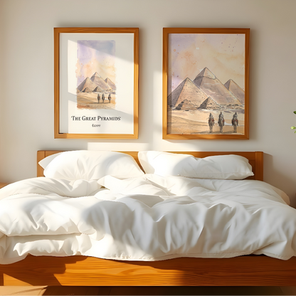 A styled bedroom scene with a wooden bed dressed in white bedding, flanked by matching nightstands and a lamp, with two framed wall art prints above the headboard showing desert pyramids.