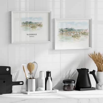 kitchen wall with two white framed travel posters in watercolour of Wadebridge over a kitchen work surface