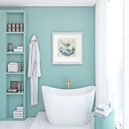 Bathroom with mint green walls, framed artwork of a whale tail in the sea on a book page background and white freestanding bathtub, and shelves with books and towels.