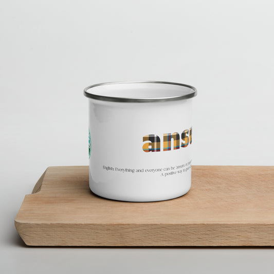 white enamel mug with cornish tartan text saying ansum on a wooden chopping board